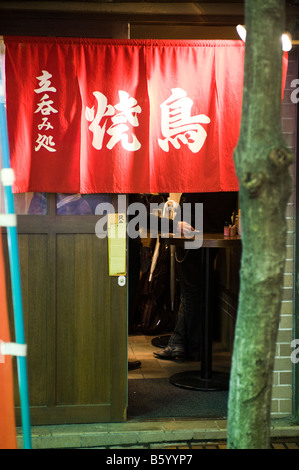 Gli uomini in piedi in un bar di Shinjuku, Tokyo, Giappone. Foto Stock