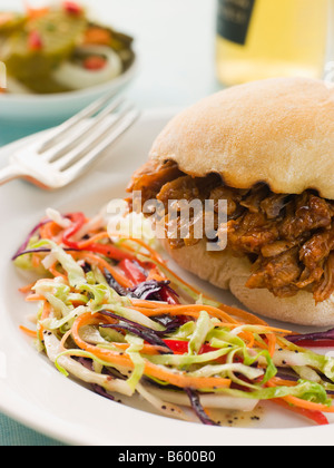 Tirate la carne di maiale e salsa barbecue rotolo con seminate Slaw e cetriolini Foto Stock