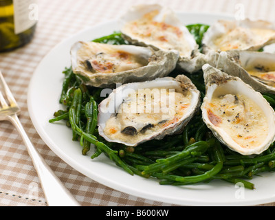 Ostriche alla griglia con salsa Mornay su Samphire Foto Stock