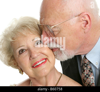 Primo piano di una amorevole senior l uomo dà la sua bella moglie un bacio sulla guancia Foto Stock