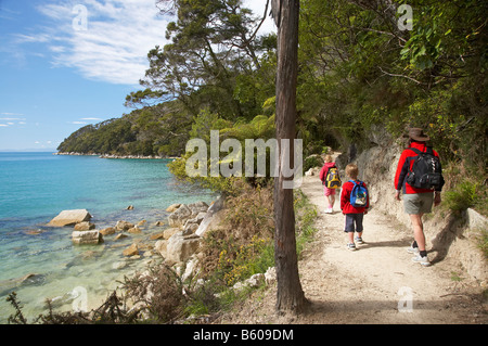 Famiglia a piedi la Abel Tasman via costiera alla Baia di corteccia di Parco Nazionale Abel Tasman Nelson regione Isola del Sud della Nuova Zelanda Foto Stock