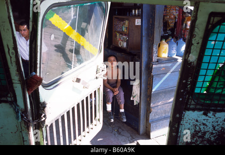 Un giovane ragazzo in una stazione degli autobus nella città di San Salvador in El Salvador Foto Stock