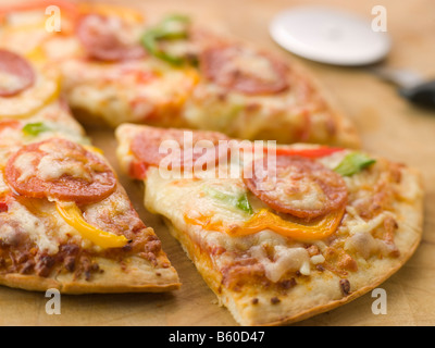 Salsiccia per pizza e Pepe Pizza con un tagliapizza Foto Stock