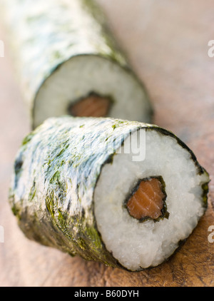 Rotolo di Sushi di salmone su una scheda Foto Stock