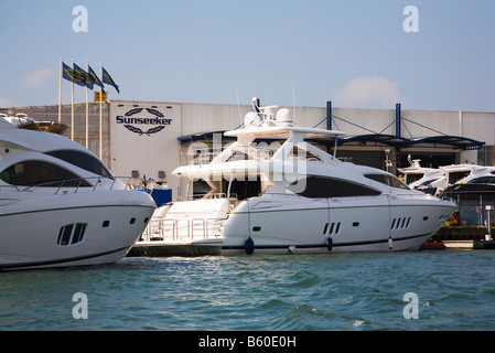 Il lusso Sunseeker barche ormeggiate al fianco del Sunseeker fabbrica nel porto di Poole, Dorset. Regno Unito. Foto Stock