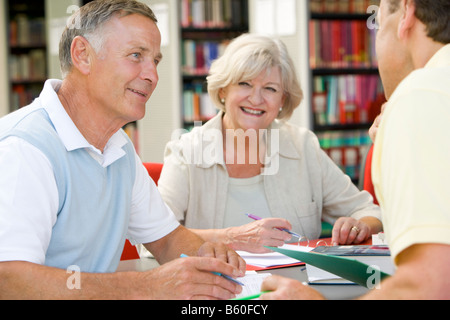 Tre persone in libreria iscritto nei notebook (messa a fuoco selettiva) Foto Stock