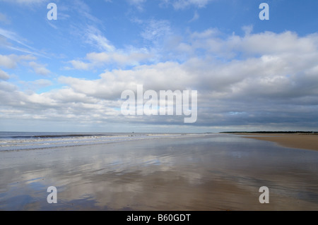 Spiaggia deserta con nuvole riflettono in sabbia bagnata Holkham Norfolk Regno Unito Ottobre Foto Stock