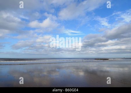 Spiaggia deserta con nuvole riflettono in sabbia bagnata Holkham Norfolk Regno Unito Ottobre Foto Stock