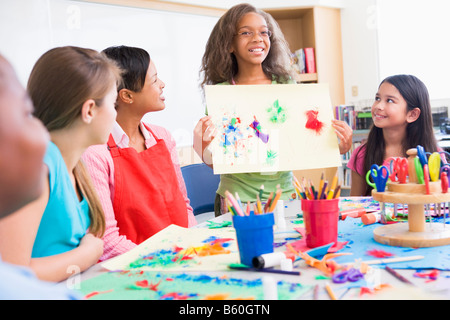 Lo studente che mostra insegnanti e compagni di classe le sue opere (messa a fuoco selettiva) Foto Stock