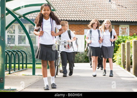 Gli studenti che lasciano la scuola con una bicicletta Foto Stock