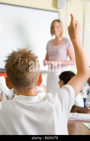 Volontariato degli studenti in classe con insegnante in pensione (messa a fuoco selettiva) Foto Stock