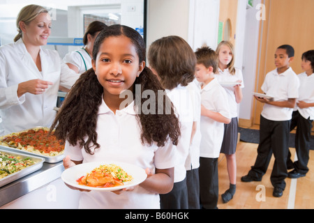 Gli studenti in linea di caffetteria con una sola azienda il suo pasto sano e guardando la telecamera (profondità di campo) Foto Stock