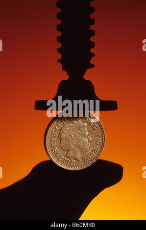 UK sterling pound coin in pinza di bloccaggio Foto Stock