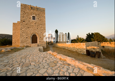 Castello e chiesa alla luce del sole di sera su un isola greca Foto Stock