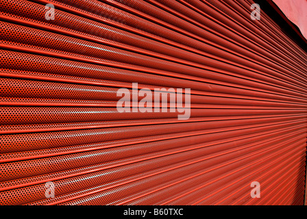 Red serranda metallica porta di sicurezza su un negozio di fronte Foto Stock