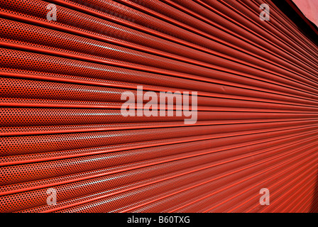 Red serranda metallica porta di sicurezza su un negozio di fronte Foto Stock