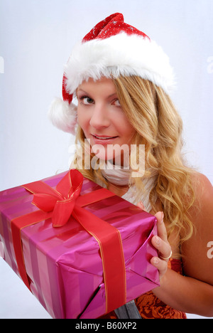 Donna che indossa un cappello di Natale con un presente Foto Stock