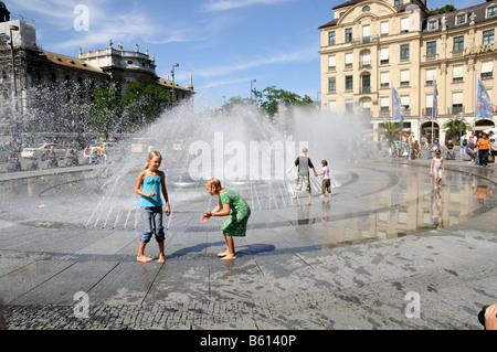 Bambini che giocano in una fontana, Karlsplatz, noto come Stachus, Monaco di Baviera Foto Stock