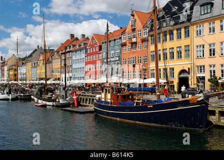 Imbarcazioni storiche di fronte a una fila di appartamento case di Nyhavn, Copenaghen, Danimarca, Scandinavia, Europa Foto Stock