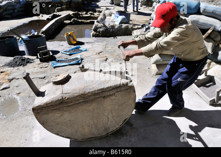 Il lavoro minorile, ragazzo di quattordici anni macinazione pietra minerale contenente, stagno, zinco, ad una polvere fine, Llallagua centro minerario, Potosi Foto Stock