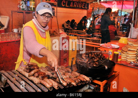 Adolescente a una salsiccia-stallo in El Alto mercato, La Paz, Bolivia, Sud America Foto Stock