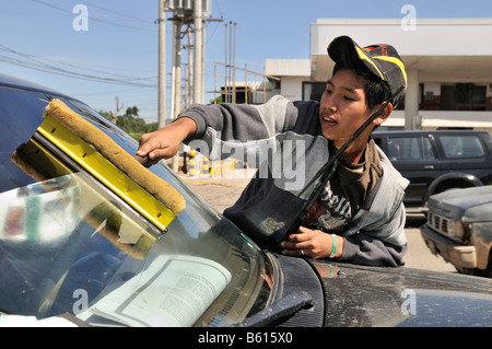 Quindici anni di vecchio ragazzo pulizia vetri auto in corrispondenza di una intersezione, Santa Cruz, Bolivia, Sud America Foto Stock