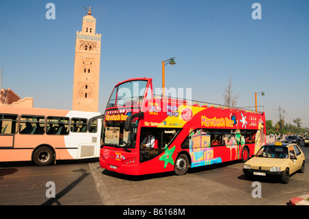 Double-decker open-top autobus turistico di fronte alla Moschea di Koutoubia, Marrakech, Marocco, Africa Foto Stock