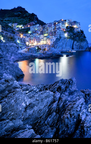 Villaggio di Manarola di notte su una ripida scogliera costiera, la Liguria Cinque Terre, Italia, Europa Foto Stock