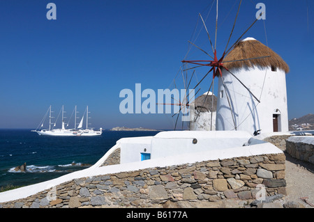 Mulini a vento e barche a vela bianca e corteccia, quattro-masted sailing ship, punto di riferimento dell'isola di Mykonos, Cicladi Grecia, Europa Foto Stock