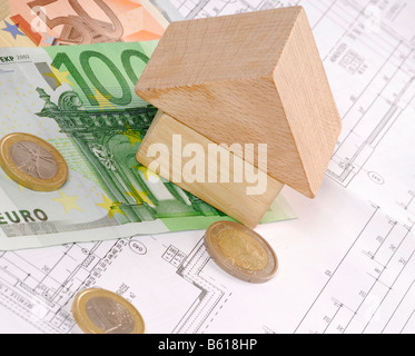 Una piccola casa su un piano di costruzione e le banconote in euro, immagine simbolica per il finanziamento della vostra casa Foto Stock