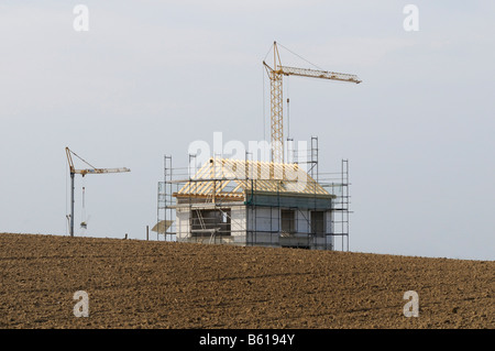 Edificio Scaffolded shell con la travatura del tetto in un campo vuoto, fiancheggiata da gru per edilizia, Mettmann, Renania settentrionale-Vestfalia Foto Stock