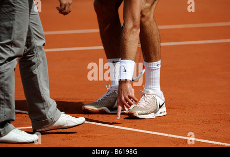 Arbitro contestato la decisione ad una partita di tennis, giocatore di tennis che mostra un arbitro con l'indice della mano sinistra la linea del campo da tennis Foto Stock