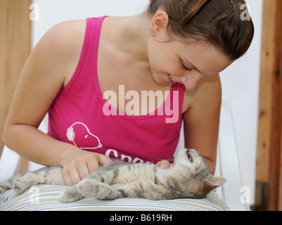 Ragazza accarezzare un gatto, Gatto godendo di esso Foto Stock