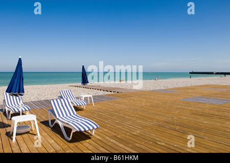 Stoney spiaggia vicino a Dieppe con sedie a sdraio e ombrelloni, in Normandia, Francia, Europa Foto Stock