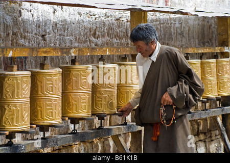 Vecchio pellegrino tibetano uomo con perle e la filatura ruote della preghiera lungo la strada al di sotto del palazzo del Potala, Lhasa, in Tibet. JMH3749 Foto Stock