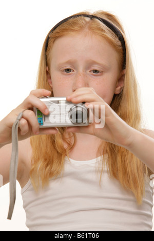 Ragazza, 8, tenendo in mano una fotocamera digitale Foto Stock