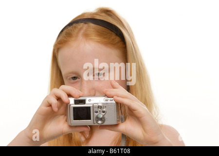 Ragazza, 8, tenendo in mano una fotocamera digitale Foto Stock