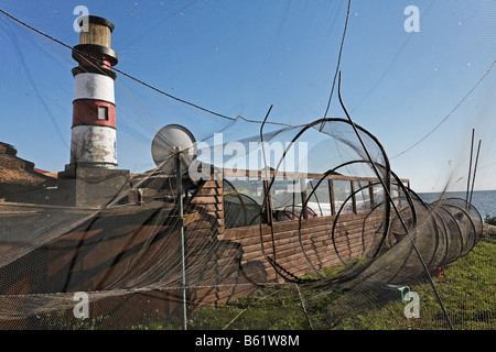 Le reti da pesca appesa ad asciugare, decorativi faro, Kaminke Harbour, Laguna/Baia di Stettino, isola di Usedom, Mecklenburg-West Foto Stock