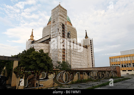 Chiesa Nikolaikirche, coperta da impalcature in modo che la facciata può essere rinnovato, avvolti in teli di plastica, parete con graf Foto Stock