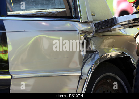 Vigili del fuoco utilizzando un attrezzo extrication per entrare in un veicolo Foto Stock