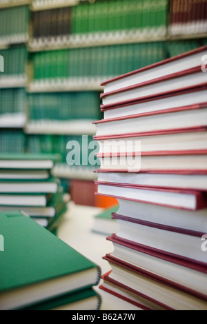 Pile di libri nella parte anteriore di un ripiano di una libreria Foto Stock