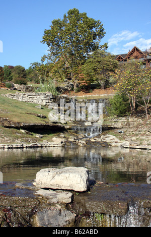 Un flusso artificiale cascata e stagno sui motivi di un hotel di Branson Missouri Lodge in background Foto Stock