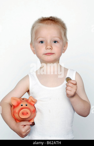 Ragazzo con un salvadanaio e monete Foto Stock