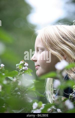 Ragazza odorare un fiore Foto Stock