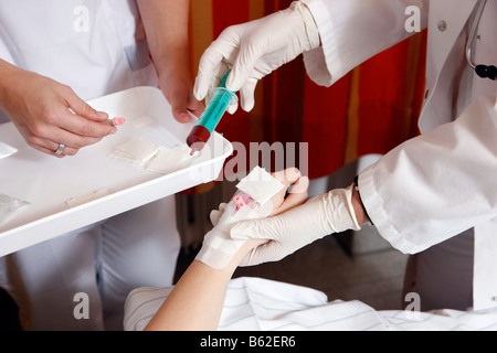 L'infermiera prelievo di un campione di sangue da un paziente in un ospedale Foto Stock
