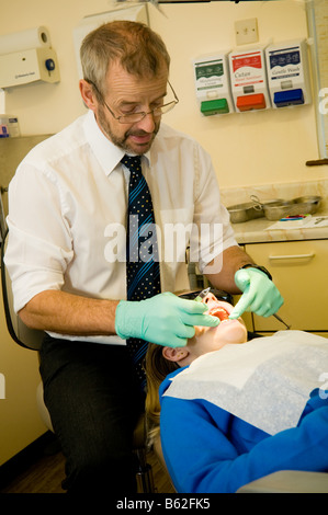 Una ragazza di quattordici anni avente i suoi denti controllati dal suo NHS National Health Service ortodontista REGNO UNITO Foto Stock