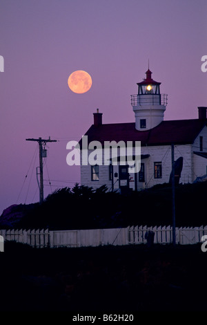 Luna piena impostazione all'alba sopra il punto di batteria faro Crescent City Del Norte County in California Foto Stock