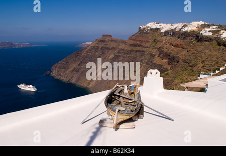 Bellissimo villaggio di Fira con il bianco di vecchi edifici e la vecchia barca guardando in giù a Santorini in isole greche in grecia Europa Foto Stock