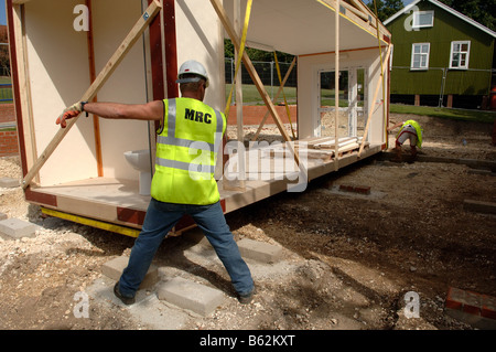 Abbassamento in costruzione modulare sezione in posizione mediante gru Foto Stock