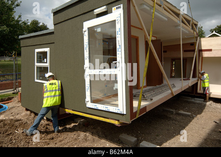 Abbassamento in costruzione modulare sezione in posizione mediante gru Foto Stock